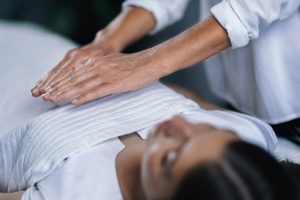 A young woman receiving a reiki healing session.