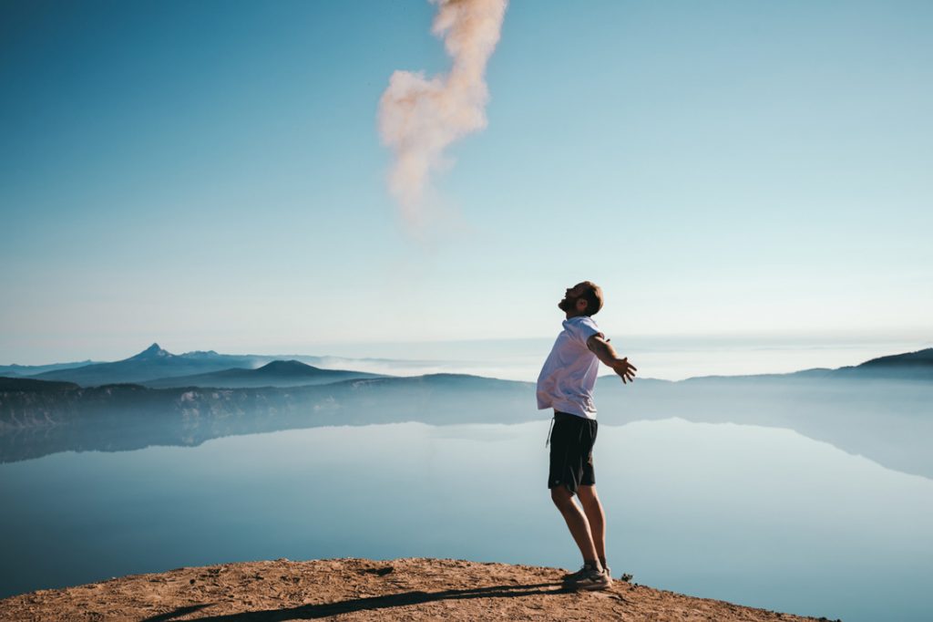 Person standing with arms open wide.