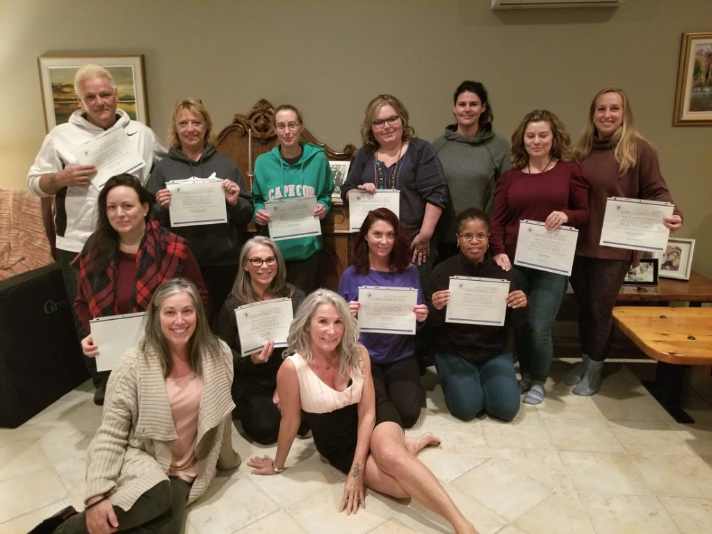 Students standing with certificates for Access Consciousness The Bars